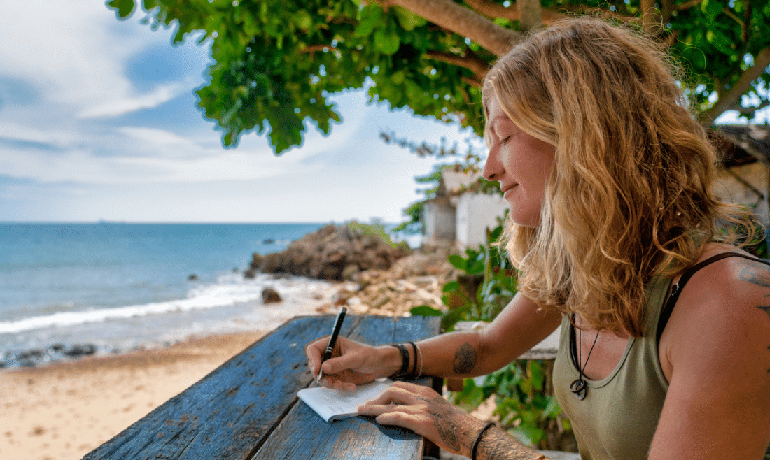 woman journaling on the beach