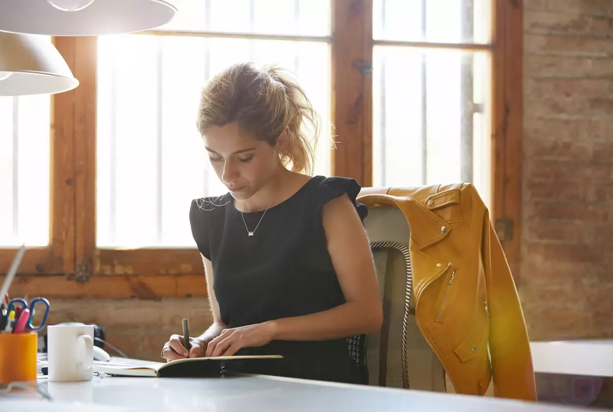 woman exploring a writing exercise at desk