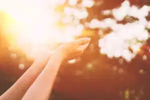 a-woman's-hands-out-near-the-sun