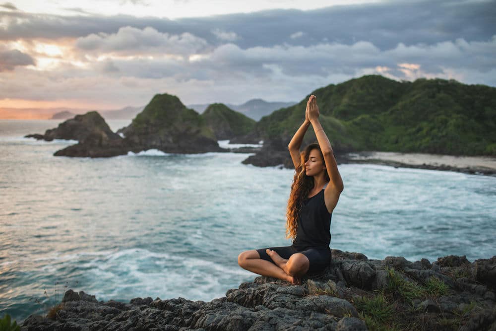 a-woman-meditating-on-the-beach