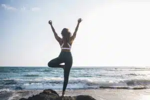 a-woman-doing-yoga-on-the-beach