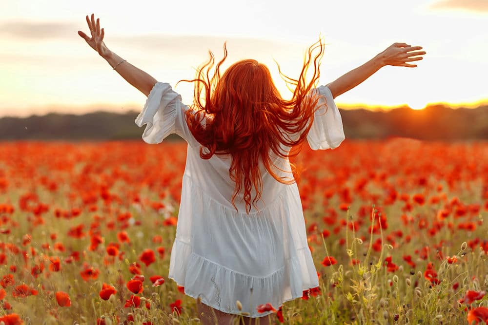 a-woman-embracing-a-field-of-flowers