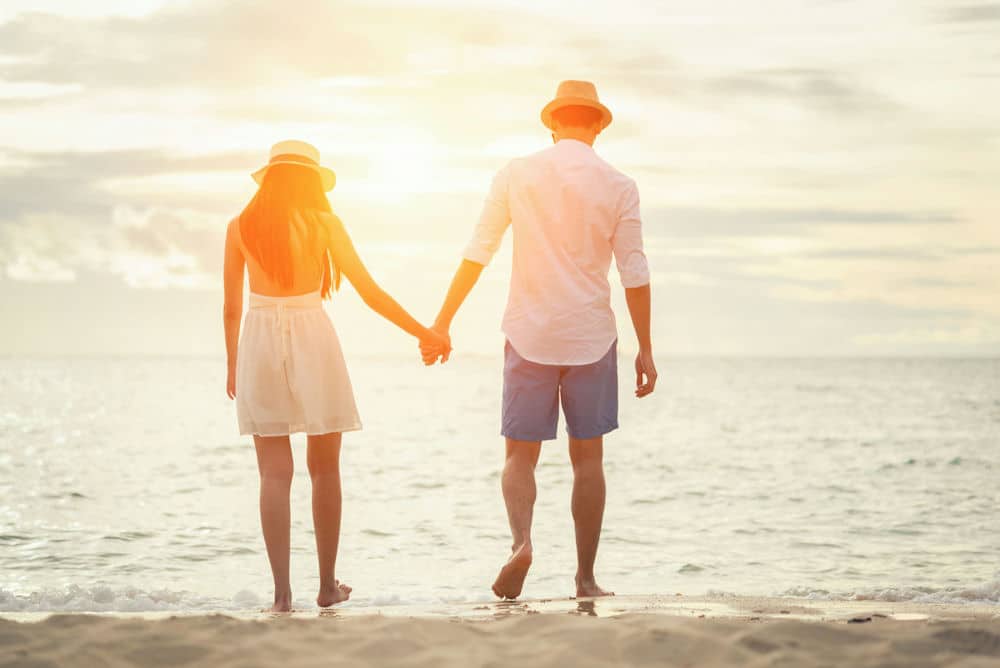 a-couple-holding-hands-at-the-beach