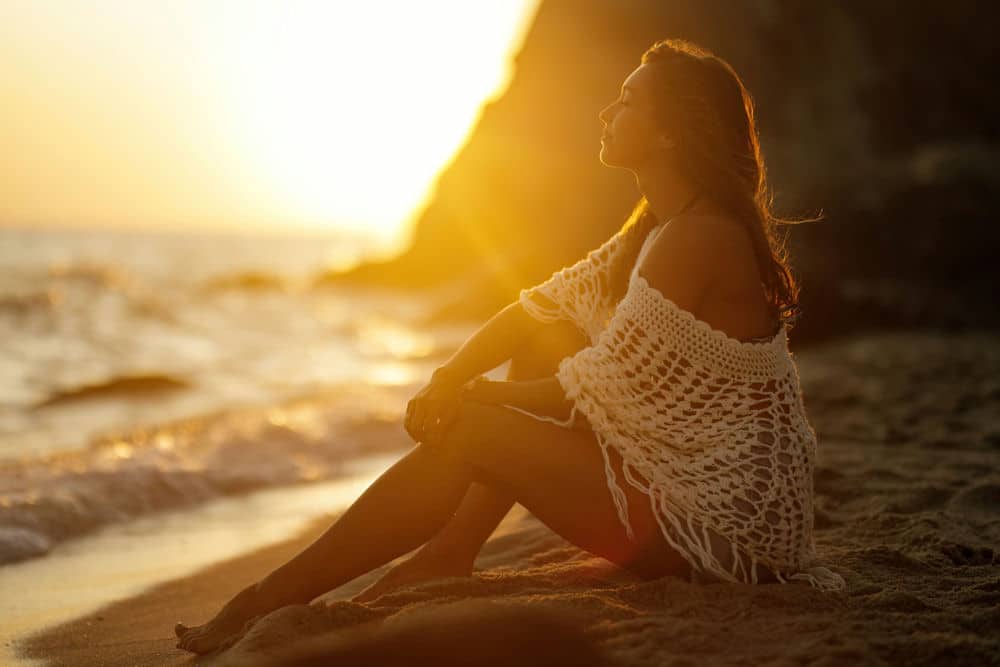 a-woman-meditating-during-the-sunset-on-the-beach