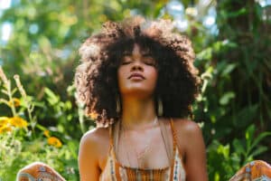 a-woman-meditating-outside-with-plants-and-nature