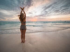 woman doing yoga at a beach