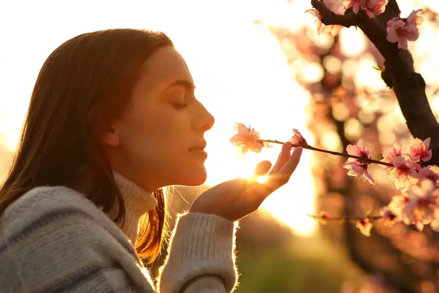 a-woman-smelling-the-flowers-during-the-sunset
