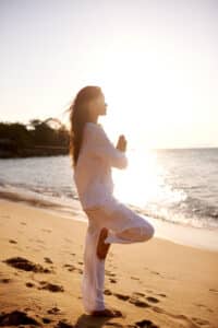 woman doing yoga at the beach