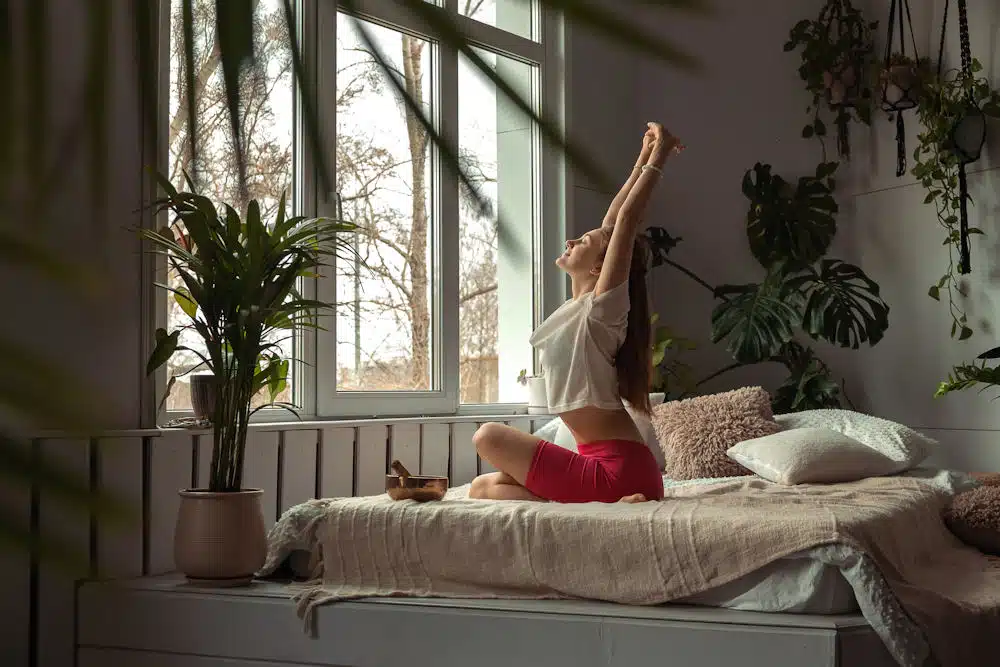 a-young-woman-stretching-on-her-bed