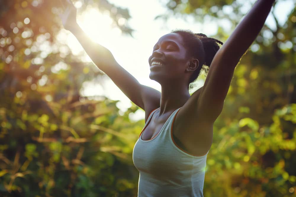 a-woman-embracing-joy-with-arms-in-the-air-outside-in-nature