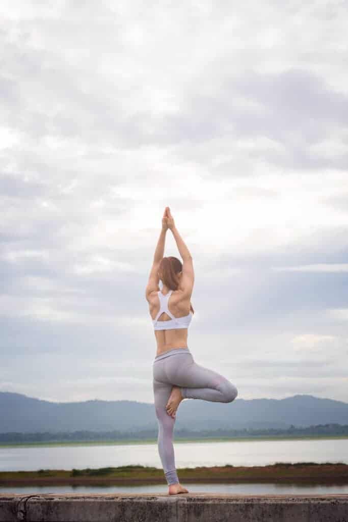 woman-practicing-yoga-on-pier