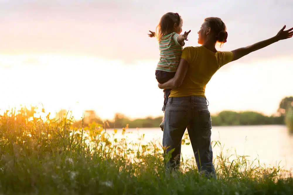 a-woman-holding-her-daughter-with-arms-raised