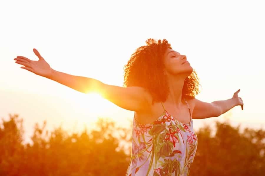 a woman with arms stretched in nature