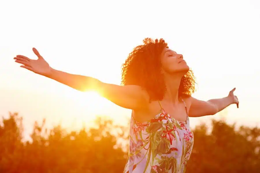 a woman with arms stretched in nature