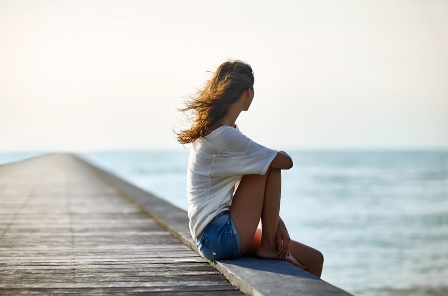 a-woman-looking-away-on-a-pier-at-the-beach