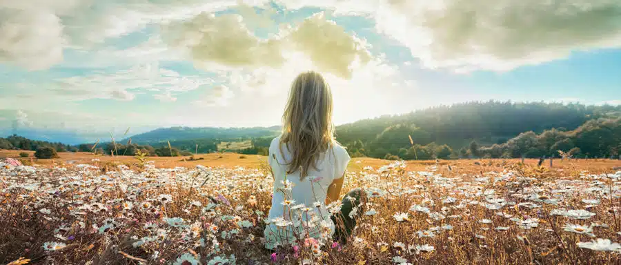 a-woman-sitting-in-a-field-of-flowers