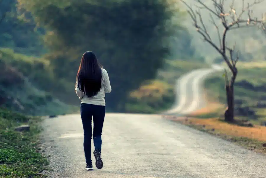 a-woman-walking-on-a-path-in-the-forest