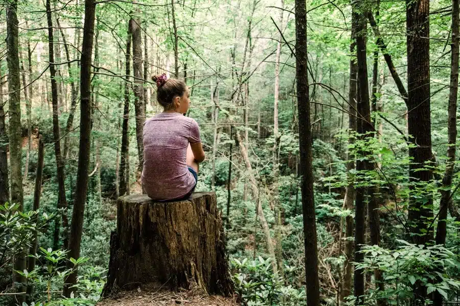 a woman thinking in the woods