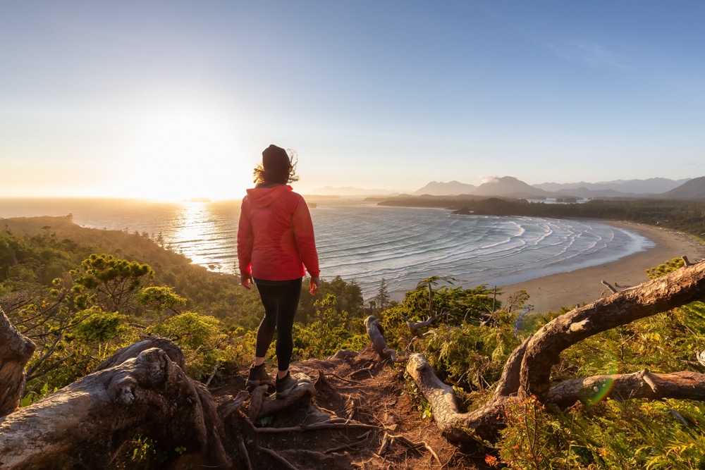 a-woman-standing-on-a-branch-at-the-beach