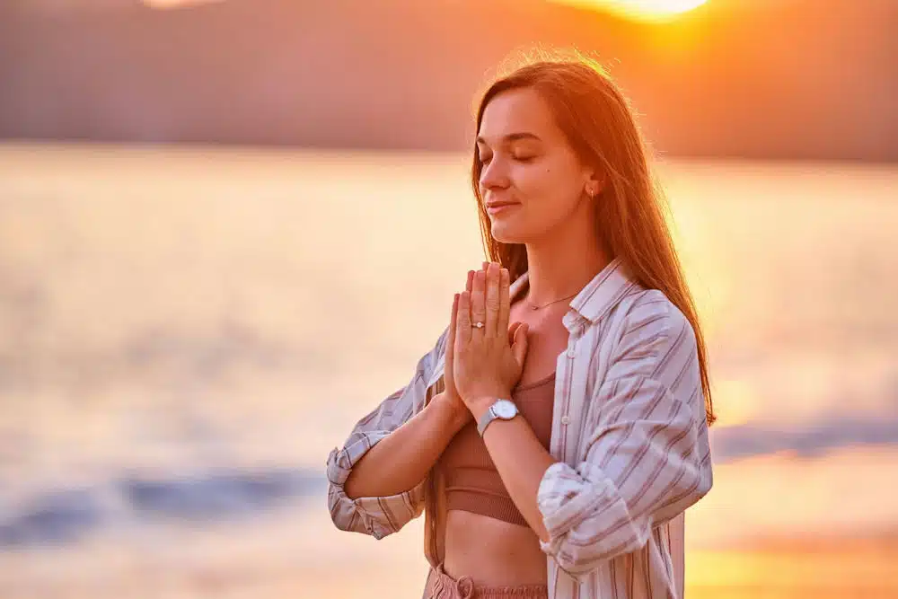 a-woman-meditating-on-the-beach