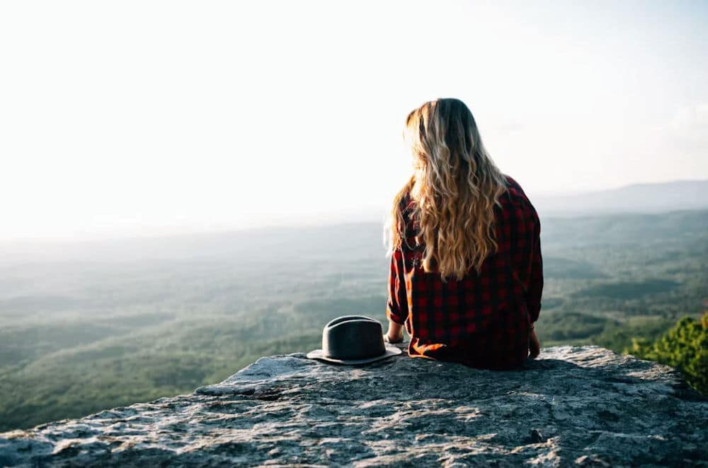 a-woman-sitting-on-a-rock