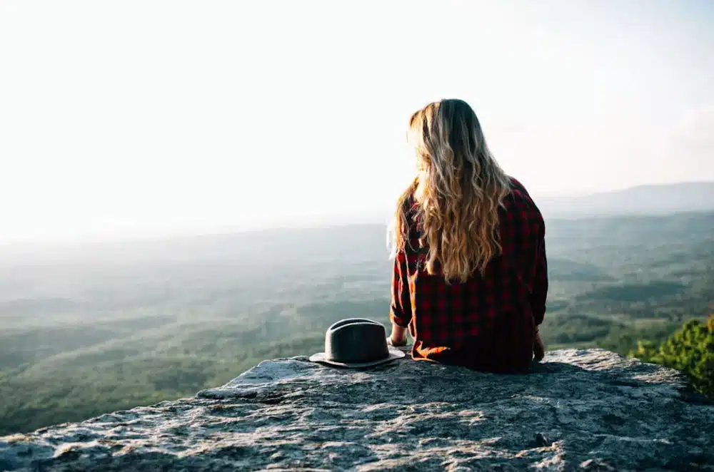 a-woman-sitting-on-a-rock